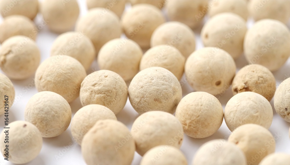 Fototapeta premium Close-up of White Peppercorns on a White Background, Culinary Spice Ingredient