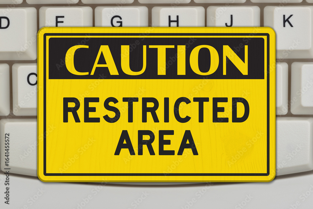 Fototapeta premium Caution Restricted Area sign on computer keyboard