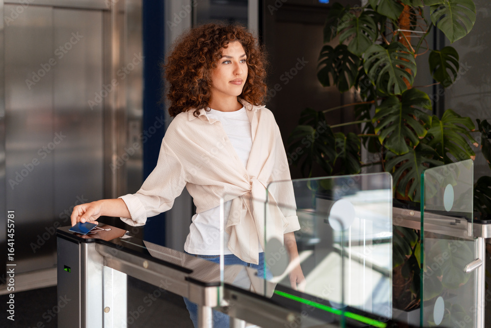 © Maria Vitkovska - Businesswoman opening office turnstile using electronic key card
