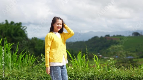 The young woman is pulling her hand toward the sunlight.