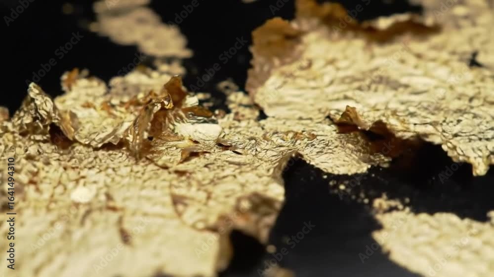 Glimmering Gold Leaf: Close-Up Texture and Abstract Artistry on Black Surface Glimmering Gold Leaf: Close-Up Texture and Abstract Artistry on Black Surface