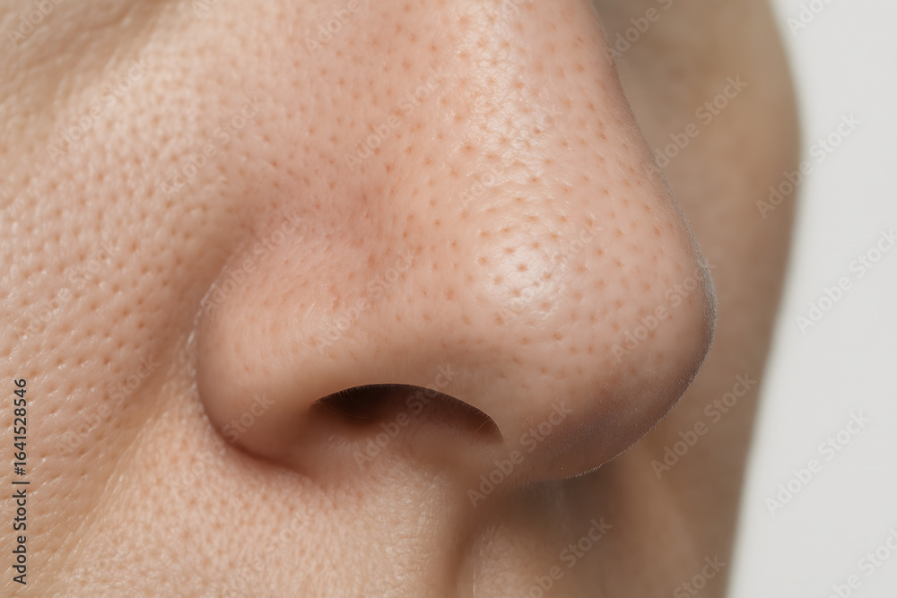 Naklejka premium Human Nose Close-Up: A detailed, macro perspective of the human nose reveals intricate skin textures and natural contours.