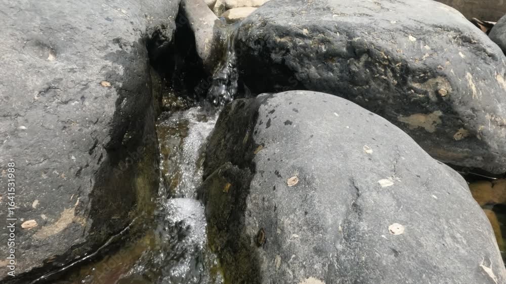 Slow motion of clear water flowing in a rocky river during the dry season. A calm and peaceful atmosphere for relaxation. Ecological and environmental concepts. 4K footage Slow motion of clear water flowing in a rocky river during the dry season. A calm and peaceful atmosphere for relaxation. Ecological and environmental concepts. 4K footage