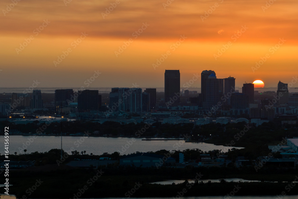 Fototapeta premium Aerial view of downtown district of Tampa city in Florida, USA at sunset. Dark silhouette of high skyscraper office buildings in modern american midtown