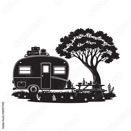 Silhouette of a vintage campervan at a picnic site under a large tree.