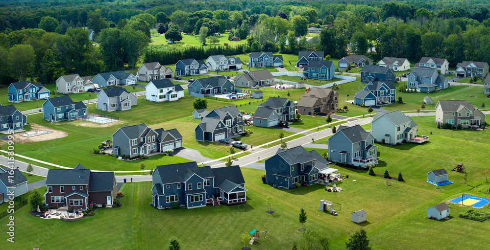 Obraz premium Low-density two story private homes with large lot size and green grassy lawns in summer season. Rural residential suburbs with upscale suburban houses outside of Rochester, New York