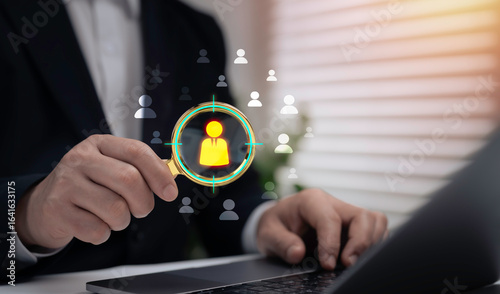 Businessman holding magnifying glass focusing on target customer icon, recruitment, employee selection, human resources strategy and business concept for finding the right candidate