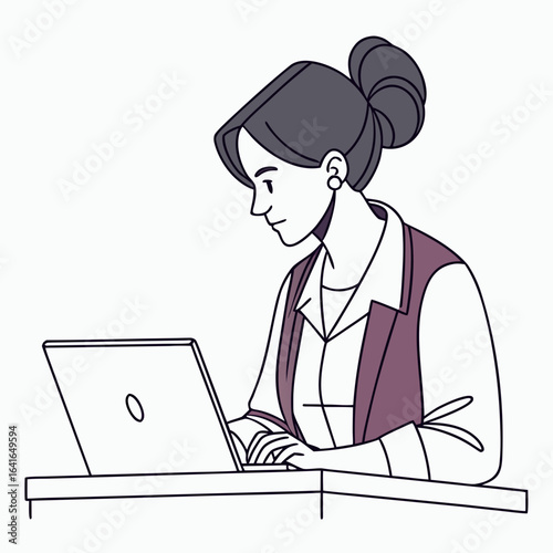 Focused woman with hair in a bun working on a laptop at a desk