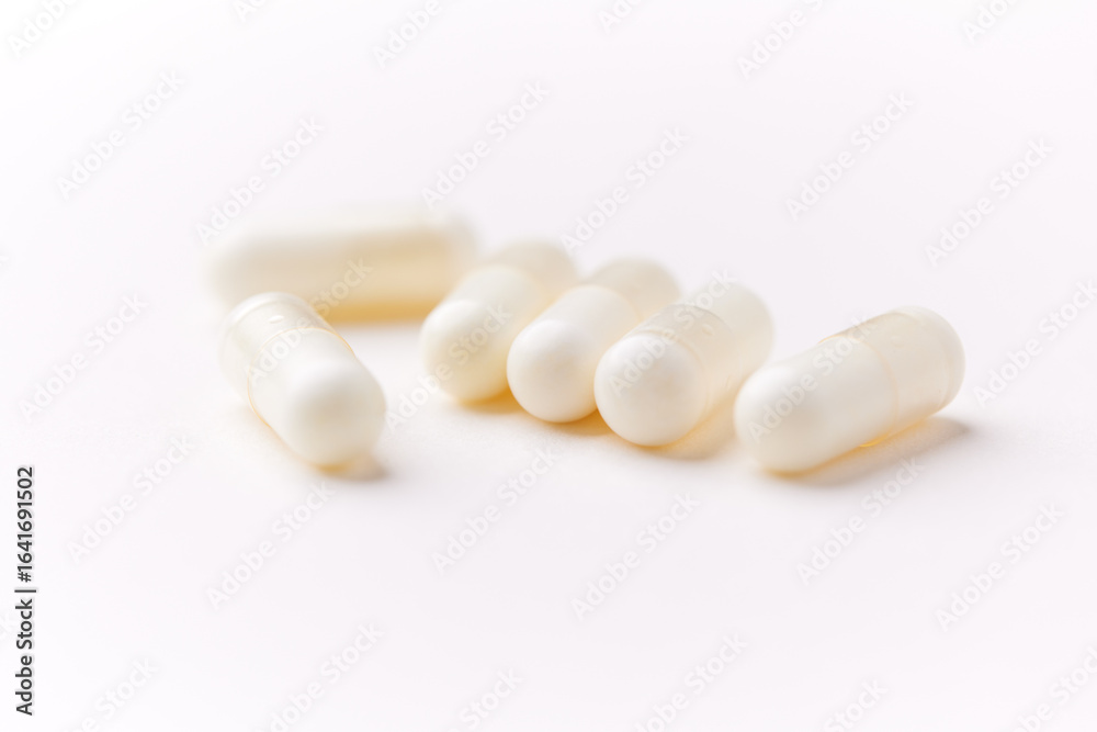 Creatine capsules on paper background. Soft focus. Close up. Copy space. Creatine capsules on paper background. Soft focus. Close up. Copy space.