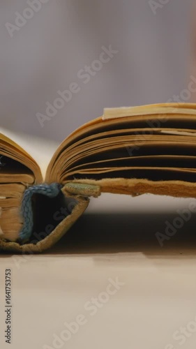 A Close-Up View Of A Person Turning Pages In An Open Vintage Book, Highlighting The Beauty Of Exploration And Reading. Vertical.