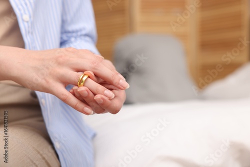 Tableau sur toile Woman taking off engagement ring after her husband's betrayal indoors, selective