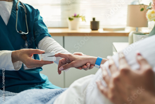 Obraz na plátne Caucasian young adult woman lying in hospital bed receiving care from medical pr