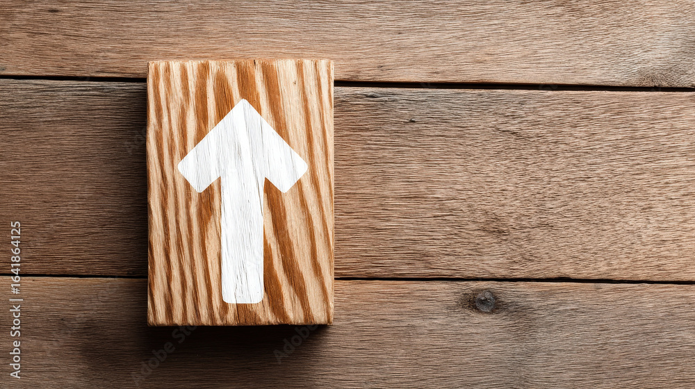 Wooden block with white arrow symbolizing growth mindset concept on rustic wooden background Wooden block with white arrow symbolizing growth mindset concept on rustic wooden background