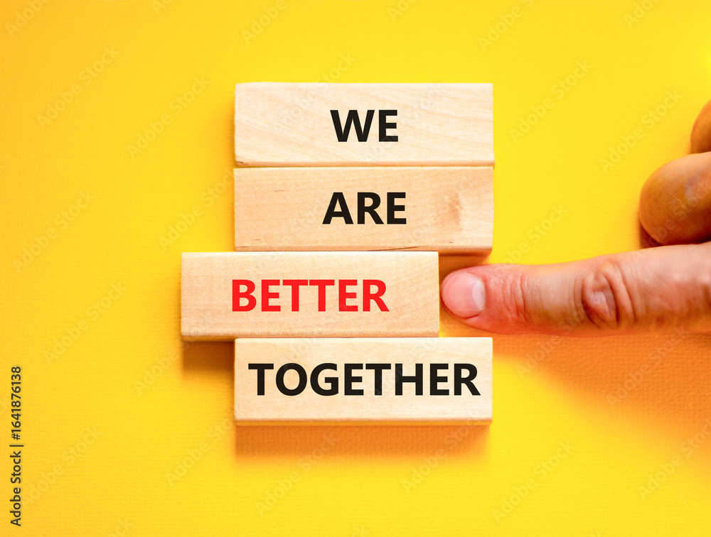 We are better together symbol. Concept words phrase We are better together on beautiful wooden blocks. Beautiful yellow background. Businessman hand. Business We are better together concept Copy space