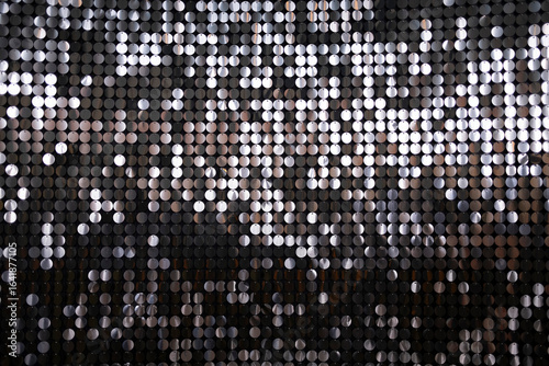 A visually striking close-up of a metallic sequined surface, reflecting light in various shades, ideal for themes of glamour and celebration