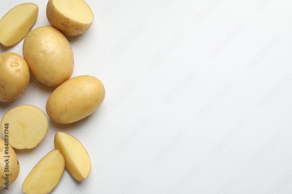 Fototapeta premium Fresh raw potatoes on light grey background, flat lay. Space for text