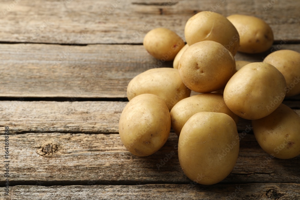 Many fresh potatoes on wooden table, closeup. Space for text Many fresh potatoes on wooden table, closeup. Space for text