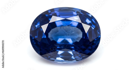 A luxurious deep blue oval-cut faceted sapphire gemstone isolated on a clean white background.