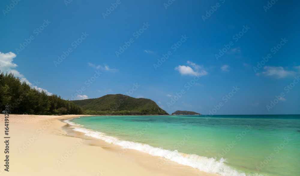 Peaceful tranquil tropical sea beach with crystal clear turquoise water gently washing onto soft sandy shore, framed by lush green hills and bright blue sky dotted with fluffy white cloud for travel Peaceful tranquil tropical sea beach with crystal clear turquoise water gently washing onto soft sandy shore, framed by lush green hills and bright blue sky dotted with fluffy white cloud for travel