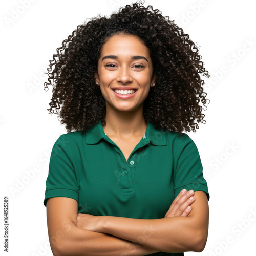 A young woman with curly dark hair smiles confidently with her arms crossed wearing a green polo shirt isolated on transparent background