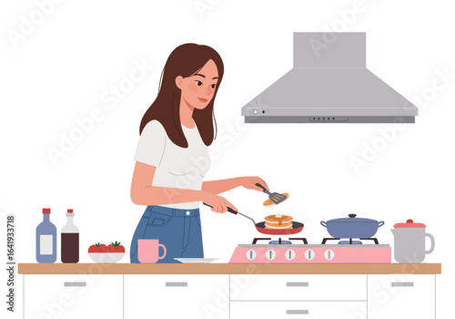 Woman cooking pancakes in a kitchen setting.