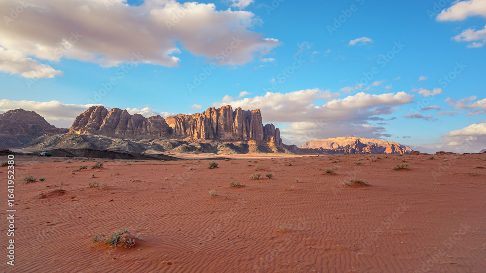 custom made wallpaper toronto digitalWadi Rum desert with red sand lit by evening sun, rocky mountain formations in background
