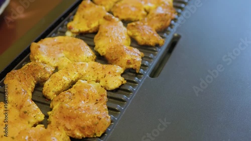 cooking chicken fillet on an electric grill at home