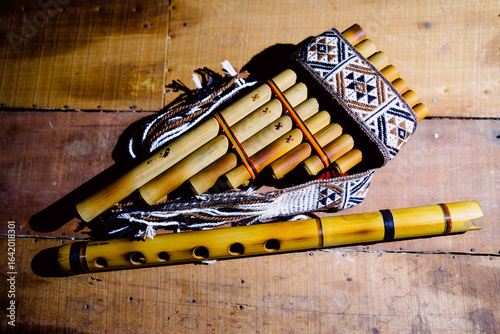 Andean flute and panpipe, traditional musical instruments of the Andes on wood with a black background