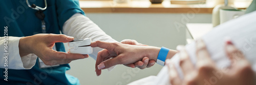 Foto Caucasian female nurse placing pulse oximeter on finger of middle aged Caucasian