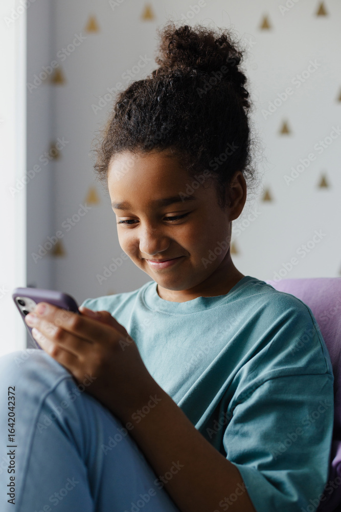 Smiling girl using smartphone at home Smiling girl using smartphone at home