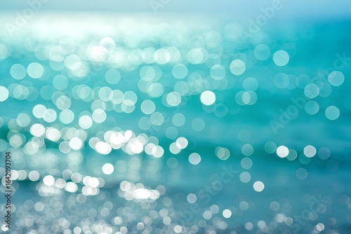 Abstract bokeh of shimmering sunlight reflecting on the surface of the blue ocean water
