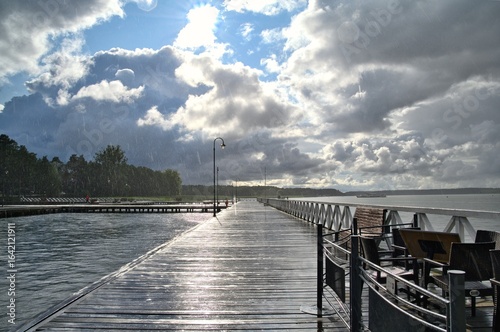 A pier on a lake on a rainy day.