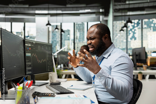 Photos Trader in office raging after losing money, reacting negatively to poor portfolio performance