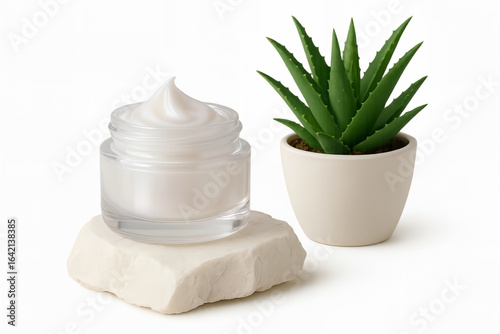 Face cream in a transparent, tattered jar standing on a quartz stone with aloe in a porcelain pot.

