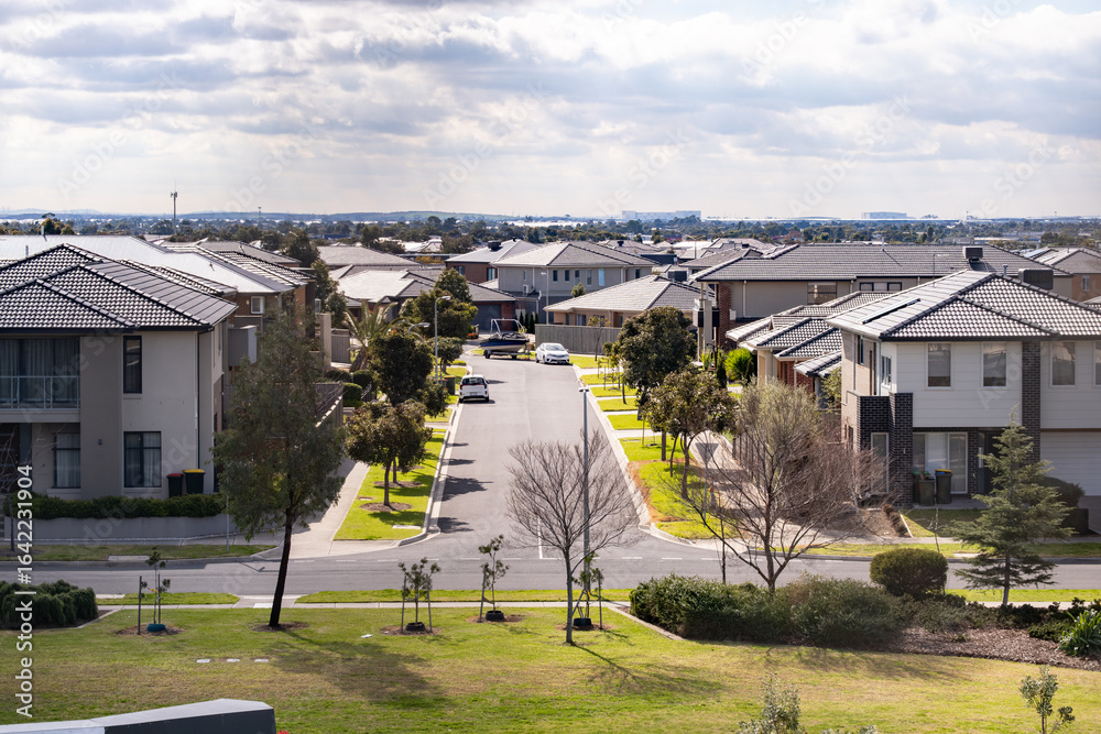 Obraz premium Aerial view of modern suburban residential street in Point Cook, Melbourne Australia,featuring contemporary double-storey houses and a quiet neighborhood atmosphere. Concept of real estate and housing