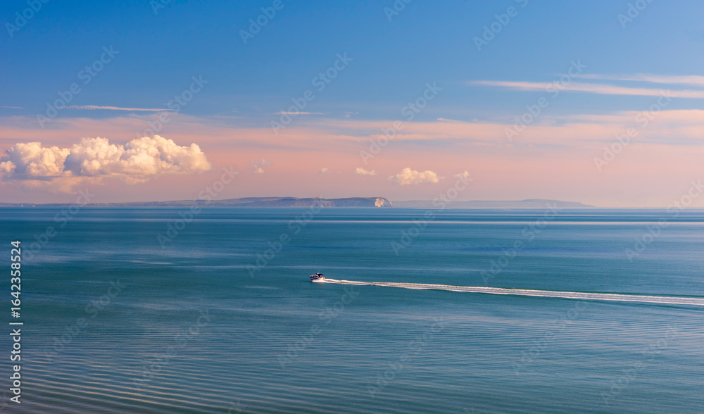 Obraz premium Isle of Wight viewed from Bournemouth beach illuminated by the low sun