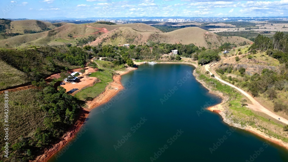 Impressionante paisagem aérea de barragem rodeada por colinas verdes e céu azul, perfeita para projetos turísticos e naturais. Impressionante paisagem aérea de barragem rodeada por colinas verdes e céu azul, perfeita para projetos turísticos e naturais.