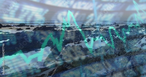 Displaying rocky tide-pool coastline at low tide under overcast, with overlaid financial chart data © vectorfusionart