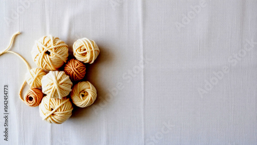 Neutral Yarn Balls on Light Textured Fabric – Corner Flat Lay with Beige and Ivory Tones, Ideal for Crafting, Textile Design, or Background Use