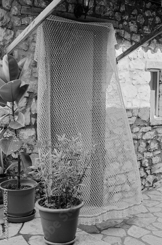 Monochrome still life of an open door with a fine curtain 