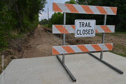 Barrier and Trail Closed sign in front of dirt road