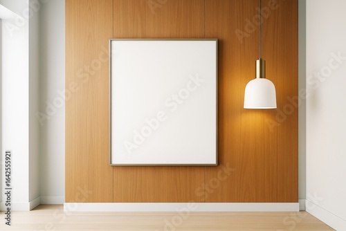 Contemporary interior with wooden wall and blank vertical frame lit by modern pendant lamp for branding or artwork mockup template display.