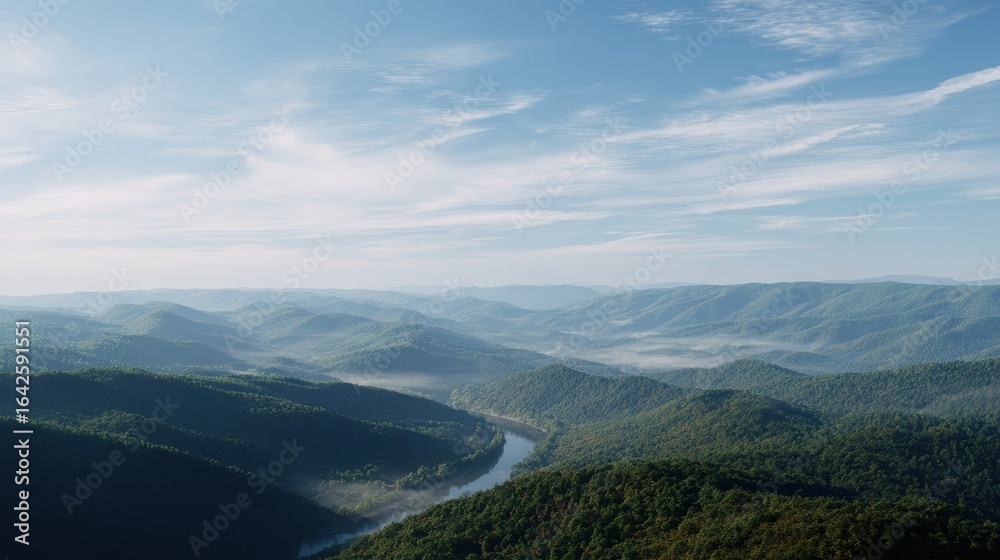 Fototapeta premium Forested mountain range stretches into the distance under a bright sky and thin clouds