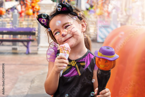 Girl in Halloween cat costume eats ice cream