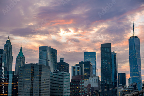 Manhattan skyline from Brooklyn Bridge at sunset.