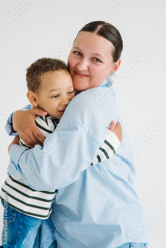 Mom and son share a warm hug in a bright studio setting