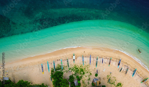 Scenic island harbor with traditional boats and turquoise sea.