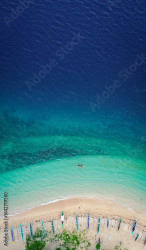 Bird’s-eye perspective of tropical paradise with moored outrigger boats.