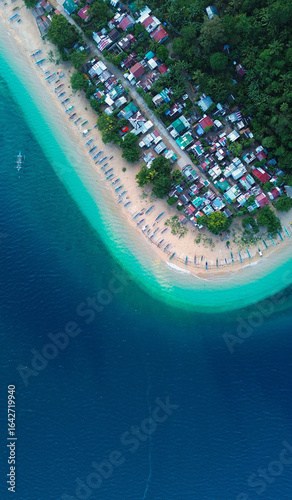 Vibrant tropical beach with moored fishing boats in the Philippines.