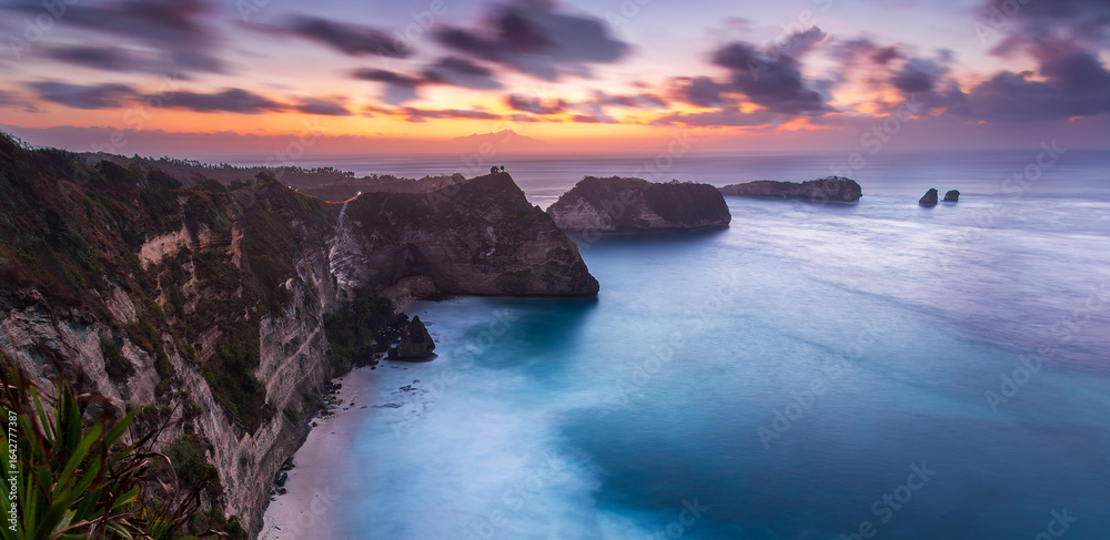 Fototapeta premium Sunrise view of scenic cliff islands and Diamond Beach at Nusa Penida, Indonesia. Crystal-clear turquoise water of the ocean. Wonderful sea view. Diamond Beach is a popular tourist attraction of Asia.